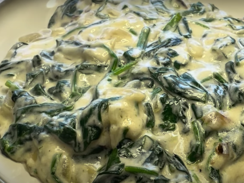 plato lleno de espinacas a la crema con queso humeantes